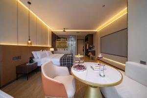 a hotel room with a bed and a table and chairs at 重庆宿江云端高空江景酒店 in Chongqing