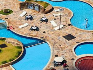 eine Aussicht über einen Pool mit Sonnenschirmen und Wasser in der Unterkunft Golden Dolphin Express in Caldas Novas