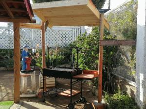 a barbecue grill in a gazebo in a garden at Cabaña la Estancia en la Isla in Isla Negra