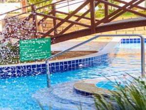 ein Schwimmbad mit einem Schild im Wasser in der Unterkunft Golden Dolphin Express in Caldas Novas