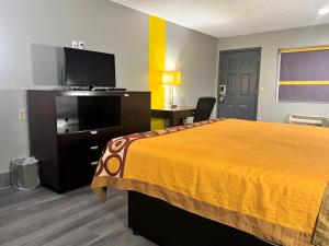 a hotel room with a bed and a flat screen tv at Super 8 by Wyndham Kosciusko in Kosciusko