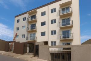 an exterior view of a white building at Apartamento central próximo ao Shopping Palladium com garagem coberta in Ponta Grossa