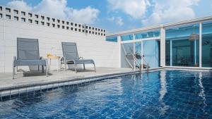twee stoelen en een tafel naast een zwembad bij Pohang Unieui Bada Poolvilla in Taebo