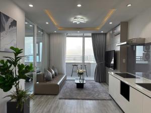 a living room with a couch and a kitchen at Da Nang Daisy Apartment in Danang