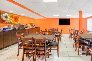 a dining room with tables and chairs and a tv at Days Inn by Wyndham Brooksville in Ridge Manor