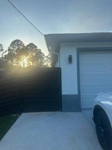 a garage with a gate and a car parked next to it at peace in Fort Myers