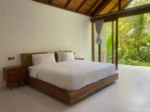 a bedroom with a bed and a large window at Antav Mesare Villa in Payangan