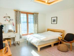a bedroom with a bed and a desk and a window at Hongcheon Riverhill Stay in Torung-gol