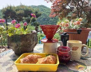 a table with a tray of food on a table with flowers at Hongcheon Riverhill Stay in Torung-gol