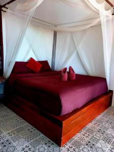 a bedroom with a bed with red pillows at Sabai Sabai Beach Bungalows in Ko Phayam