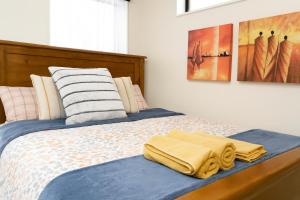 a bedroom with a bed with two towels on it at Stonebrook Haven - AC Room, Dedicated Bath, Free Parking in Family House in Rolleston +3 photos