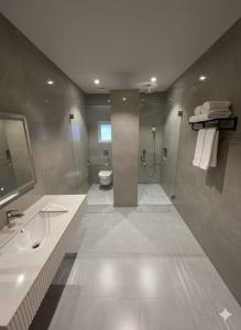 a bathroom with a shower and a toilet and a sink at Central Residence by Paramount Hospitality in Karachi