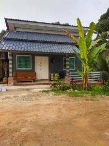 a house with a palm tree in front of it at Teratak Desa Cemerlang 2 in Kuala Kangsar