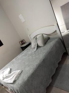 a bedroom with a bed with a white headboard at Pousada Duda Lins in São Vicente