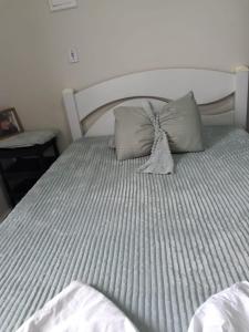 a bed with two pillows on top of it at Pousada Duda Lins in São Vicente