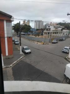 a city street with cars parked in a parking lot at Pousada Duda Lins in São Vicente