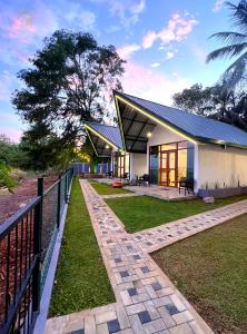 une maison avec un toit noir et une clôture dans l'établissement Sunrise Lake Resort, à Polonnâruvâ 20 autres photos