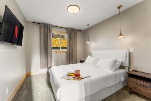 a bedroom with a white bed with a tray of fruit on it at 1 Block from Main St Views Pets Okay in Leadville