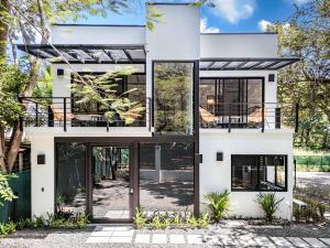 ein weißes Haus mit schwarzen Fenstern und Türen in der Unterkunft Luxury villa walking distance to Playa Grande in Refundores
