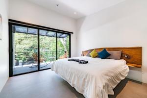 ein Schlafzimmer mit einem großen Bett und einem großen Fenster in der Unterkunft Luxury villa walking distance to Playa Grande in Refundores