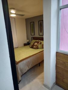 un dormitorio con una cama y una ventana en Don Bosco Leon, en San José de Malpaso