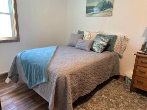 a bedroom with a bed with pillows on it at The Blue Bliss in Saint Ignace