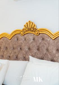 a close up of a bed with a gold headboard at La Gabbanee Hotel Boutique in Fernando de la Mora +4 photos