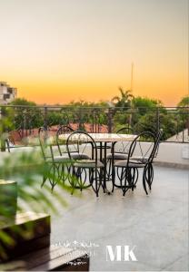 a table and chairs on a balcony with the sunset at La Gabbanee Hotel Boutique in Fernando de la Mora +4 photos