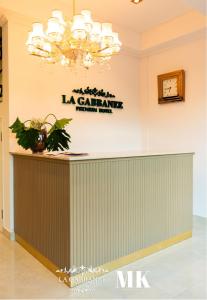 a reception desk in a lobby with a chandelier at La Gabbanee Hotel Boutique in Fernando de la Mora