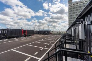 an empty parking lot with cars and a building at HOTEL R9 The Yard Kasama in Tomobe