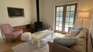 a living room with a couch and a table at Pear Tree Cottage in Apollo Bay