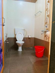 a bathroom with a toilet and a red bucket at DELTA HOUSE, Horizon View in Calangute