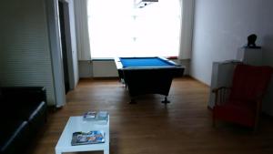 uma sala de estar com uma mesa de bilhar e um sofá em Holiday Home Goesting em Nieuwpoort
