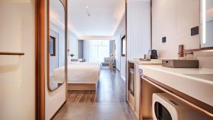 a bathroom with a sink and a bed in a room at Elong Hotel Beijing Chang'an Tianjie Bridge Huiying Metro Station Branch in Beijing +40 photos