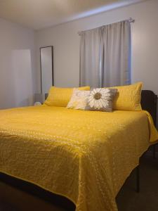 a bedroom with a yellow bed with a yellow comforter at The Cambridge of Carolina in Clayton
