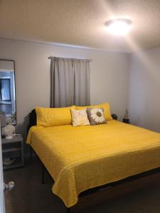 a bedroom with a bed with yellow sheets and a window at The Cambridge of Carolina in Clayton