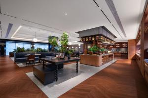 a lobby of a restaurant with a table and chairs at 上海虹桥中心城际酒店 in Shanghai