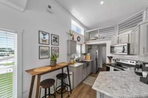a kitchen with white cabinets and a counter with stools at Moonlight Views #54 Firefly Resort in Fredericksburg