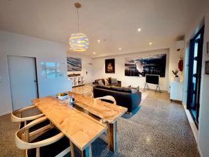 a living room with a wooden table and a couch at Luxury Waterfront Marina Apartment - Bay of Islands, New Zealand in Opua