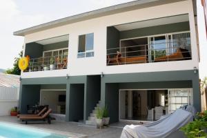a house with a balcony and a swimming pool at SHUSHI APARTMENT in Lamai