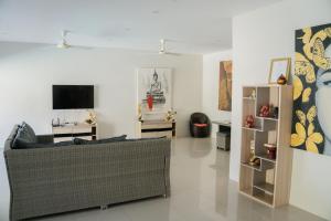 a living room with a couch and a tv at SHUSHI APARTMENT in Lamai