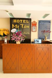 ein Hotel mein Steuerschild auf einem Schrank mit Blumen in der Unterkunft Mỹ Tân Hotel HCM in Ho-Chi-Minh-Stadt