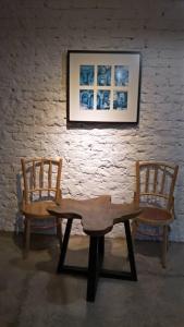two chairs and a wooden bench in front of a wall at Rareheart Guesthouse in Kuala Terengganu