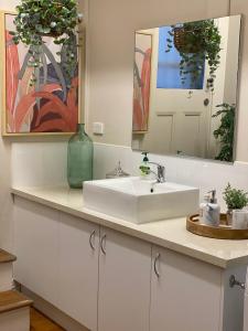 Un baño con un lavabo blanco y un espejo. en Sandhurst View, Bendigo CBD Apartment, en Bendigo