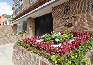 a flower garden in front of a building at Quinta Park 43 in Bogotá