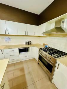 a kitchen with white cabinets and a stove top oven at Entire 4 Bed Rooms Sanctuary in West Hoxton
