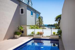 a swimming pool in front of a house at Wharf Apartment Unit 5 in Narooma