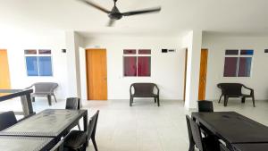 a room with chairs and tables and a ceiling fan at Habitacion Manglares 101 in Coveñas