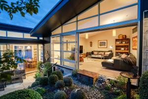 een woning met een grote glazen uitbouw met een woonkamer bij Roseneath Escape - Panoramic Harbour Views in Wellington