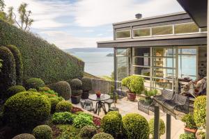 een huis met een tuin met uitzicht op de oceaan bij Roseneath Escape - Panoramic Harbour Views in Wellington